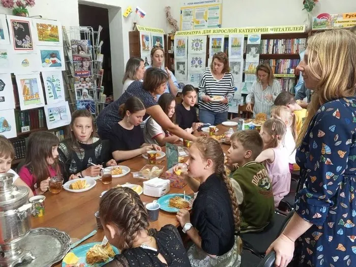 На фото родители помогают накрыть чайный стол