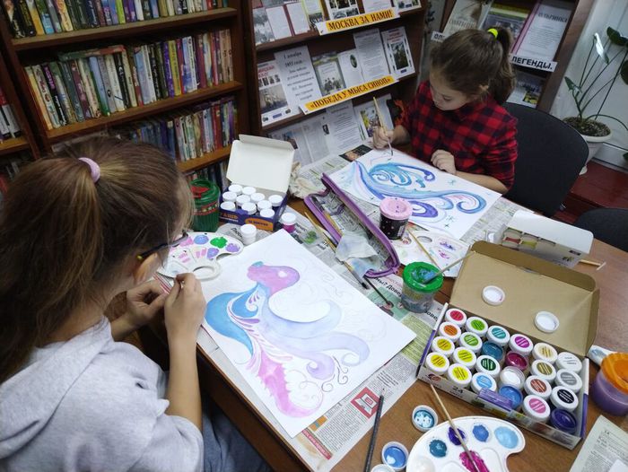 На фото творческий процесс, дети увлечены рисованием зимних узоров